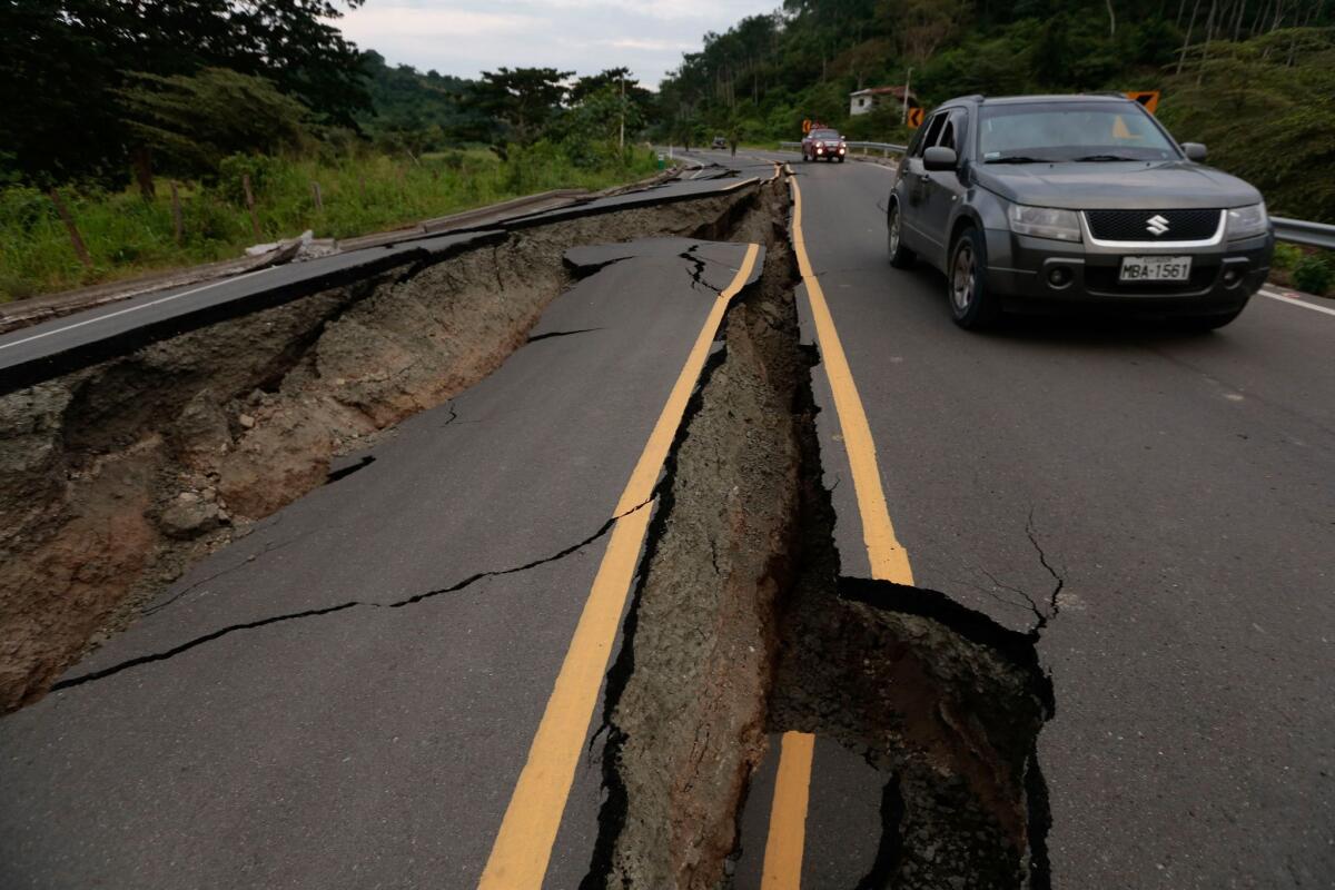 A vehicle rolls on a cracked route after a 7.8-magnitude quake in Chone, Ecuador.