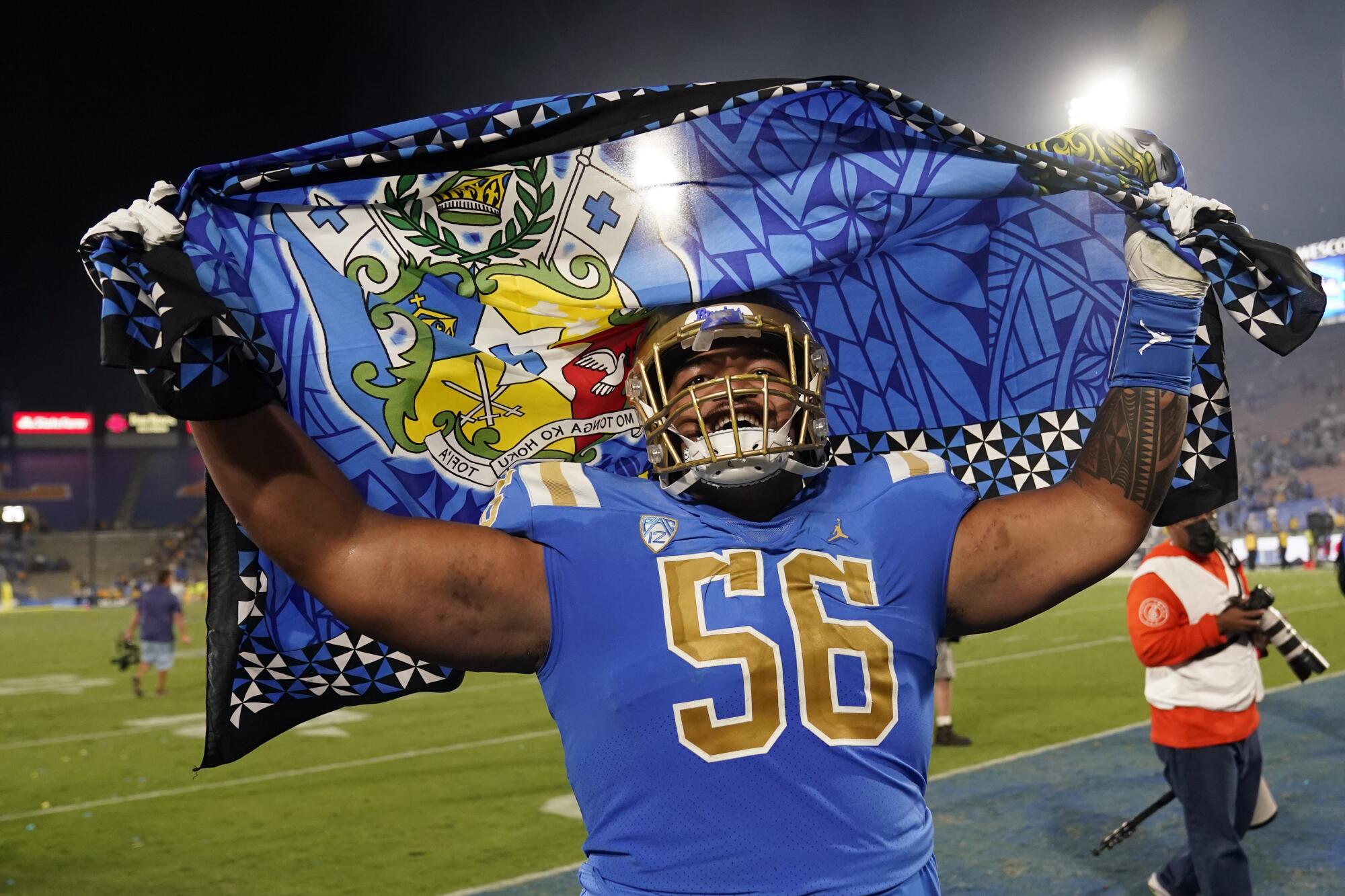 UCLA offensive lineman Atonio Mafi waves a flag as he celebrates the team's win over LSU.