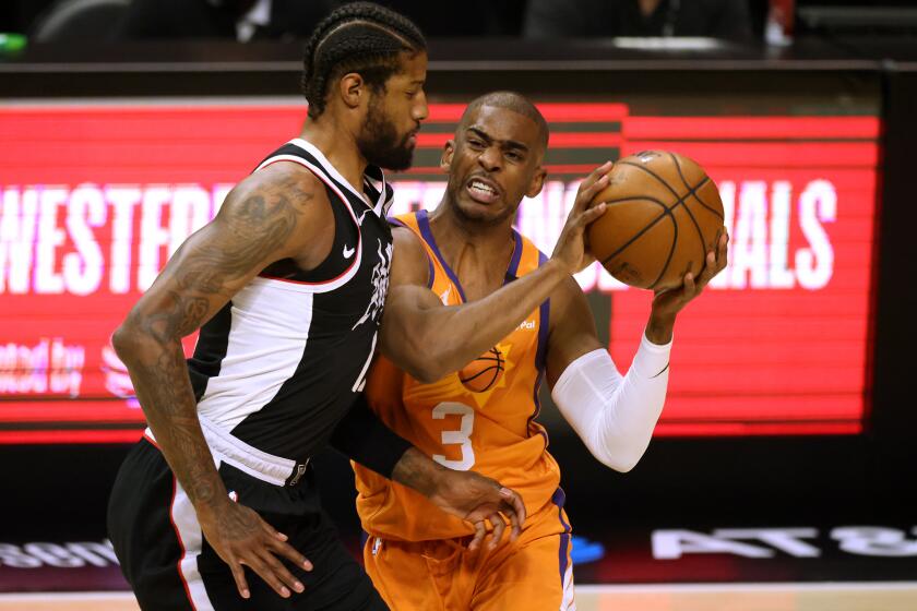 Suns guard Chris Paul is closely defended by Clippers forward Paul George during Game 3.
