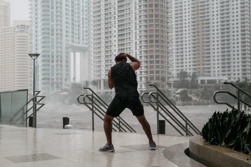MIAMI, FLA. -- SUNDAY, SEPTEMBER 10, 2017: A man stands firm against the wind by the Miami river as the water lever surges during the passing of Hurricane Irma in Miami, Fla., on Sept. 10, 2017. (Marcus Yam / Los Angeles Times)