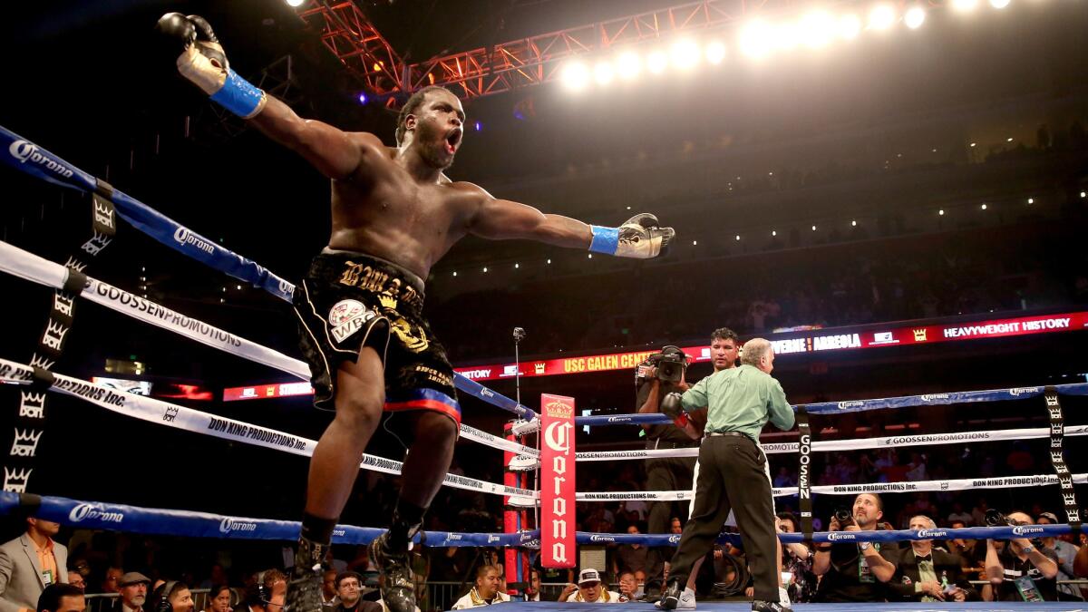 Bermane Stiverne celebrates as referee Jack Reiss holds Chris Arreola against the ropes on May 10, 2014.