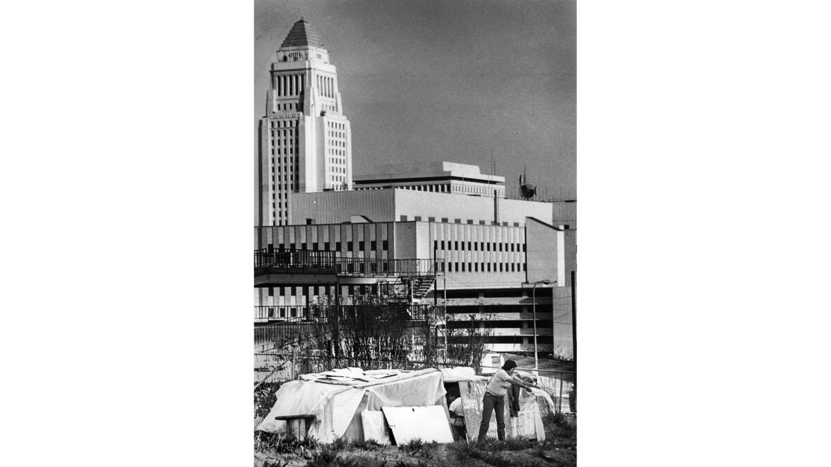 Feb. 5, 1984: Wilma Aros does household chores at a makeshift shelter on Bunker Hill under the shadow of Los Angeles City Hall.