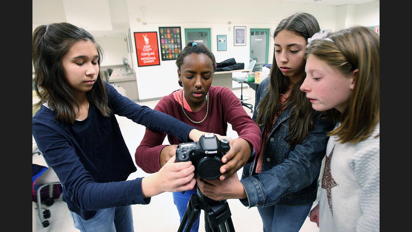 Clarissa Hodges, 13, and Tsehay Driscoll, 11, work together to hold the camera and attach a quick-release mount as fellow teammate Anese Nadaf, 13, holds the tripod and Leslie Dick, 13, observes in the brand new LCTV, La Cañada High School's new communications, broadcasting and production center on Tuesday, January 17, 2017.