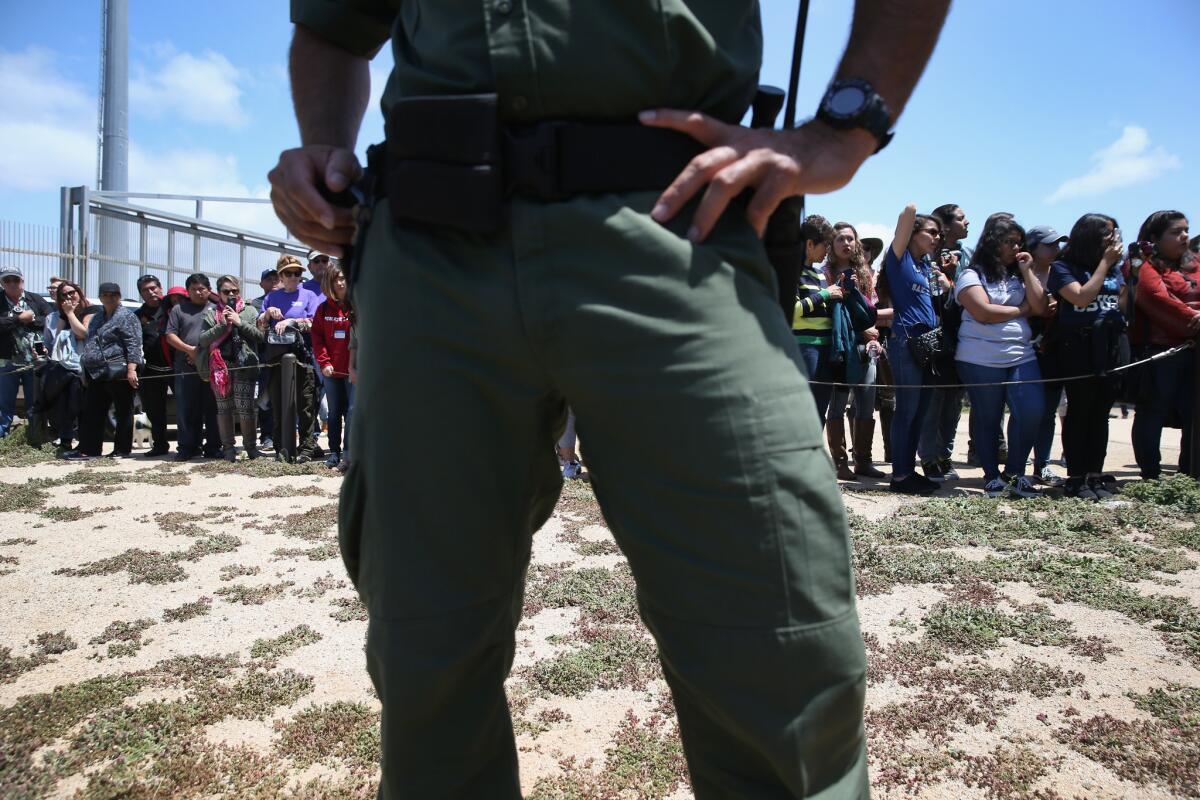 A Border Patrol agent stands guard as families prepare to meet loved ones at the U.S.-Mexico border fence separating Tijuana and San Diego.