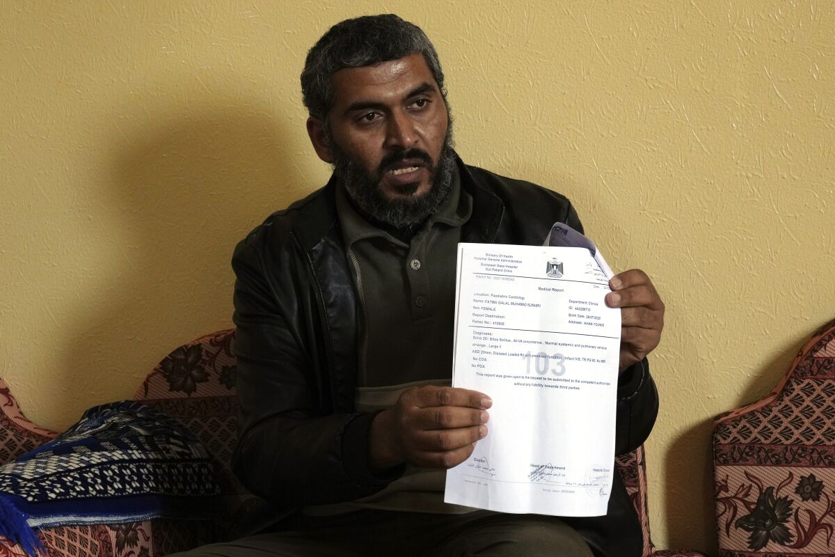 A man holds up stapled documents, showing a page marked with a large "103."