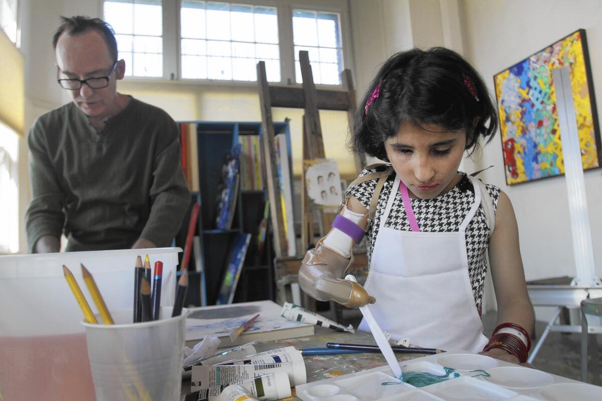 Shah Bibi Tarakhail, 6, takes a painting lesson from abstract artist Davyd Whaley in his Los Angeles studio.