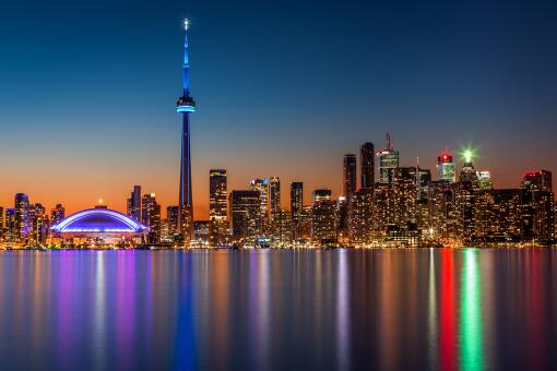 A photo of the Toronto, Canada skyline at dusk, viewed from Toronto Island park.