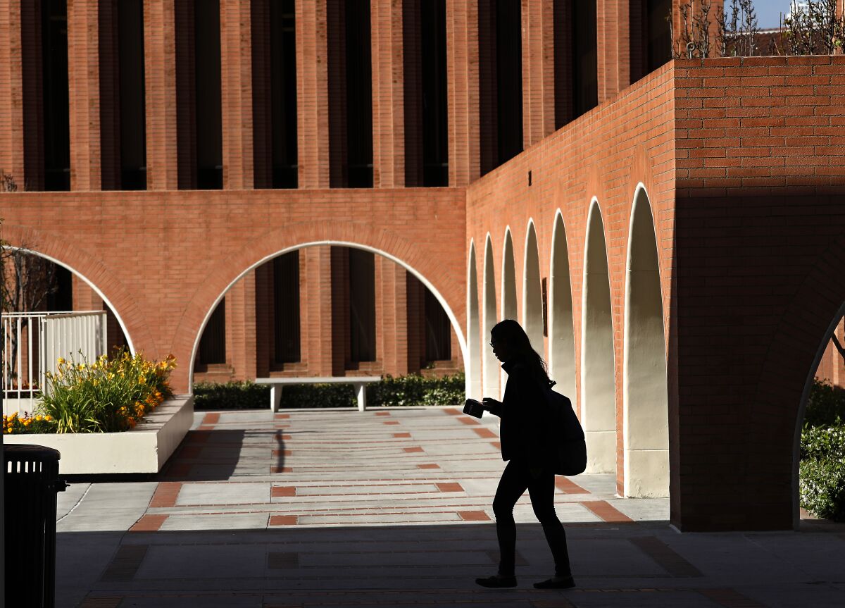 A person, in silhouette, walks on USC campus in 2018.