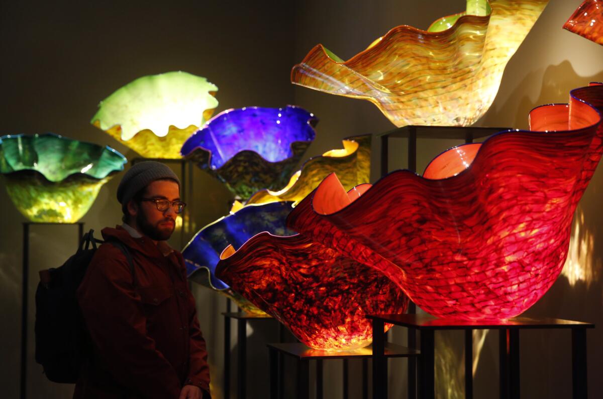 JANUARY 16, 2015. SEATTLE, WA. A visitor studies the work of artist Dale Chihuly at the Chihuly Garden and Glass museum in the Seattle Center. (Don Bartletti / Los Angeles Times)