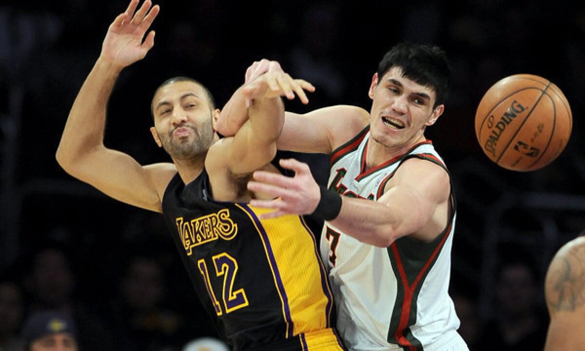 Lakers guard Kendall Marshall, left, battles Milwaukee's Ersan Ilyasova for a loose ball during the Lakers' loss Tuesday. Marshall, who has been with the Lakers for less than a month, is poised to take over as the team's starting point guard.