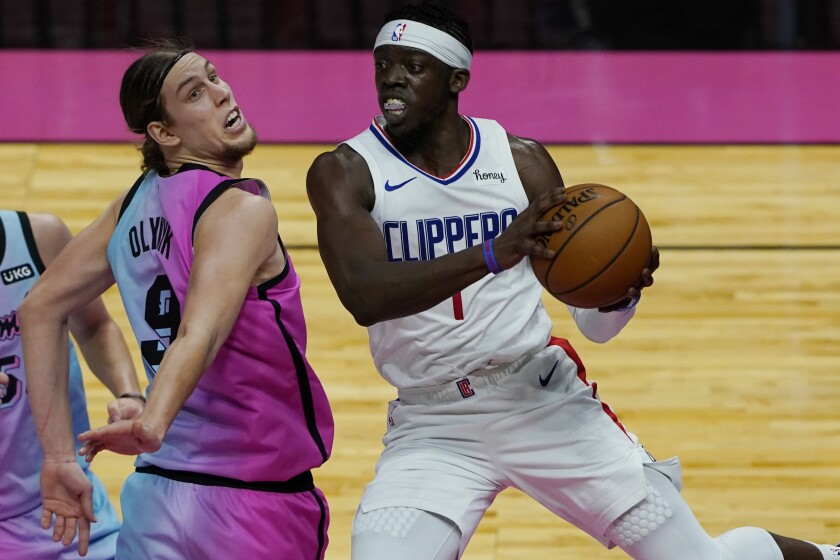 Clippers guard Reggie Jackson grabs a rebound ahead of Miami Heat forward Kelly Olynyk.
