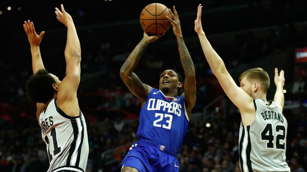 Clippers guard Lou Williams shoots a fadeaway jumper over Spurs defenders Bryn Forbes and Davis Bertans during their game Thursday night.
