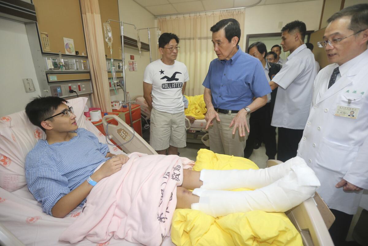 El presidente de Taiwán, Ma Ying-jeou, en el centro, habla con una víctima herida en una explosión accidental durante un concierto musical, en una visita al hospital local en Nueva Taipei, Taiwán, el domingo 28 de junio de 2015. (Central News Agency via AP)