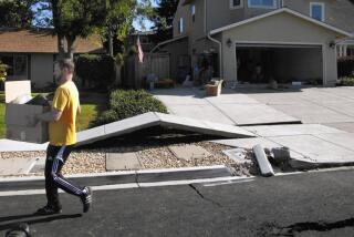 Scott Whitlock walks over a stretch of buckled sidewalk while helping his parents move out of their damaged home in 2014.. The fault line was unknown to geologists before it ruptured in Napa.