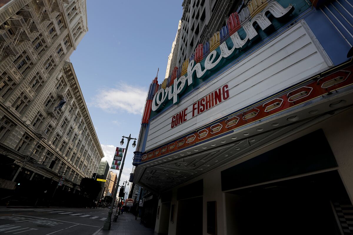 Words on the Orpheum theater marquee try to bring levity to the current situation along the normally bustling commercial area on Broadway in downtown Los Angeles, which is largely deserted because of the coronavirus lockdown.