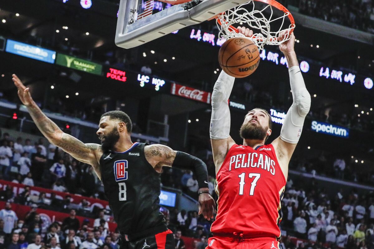 New Orleans Pelicans center Jonas Valanciunas slam dunks over Clippers forward Marcus Morris Sr.