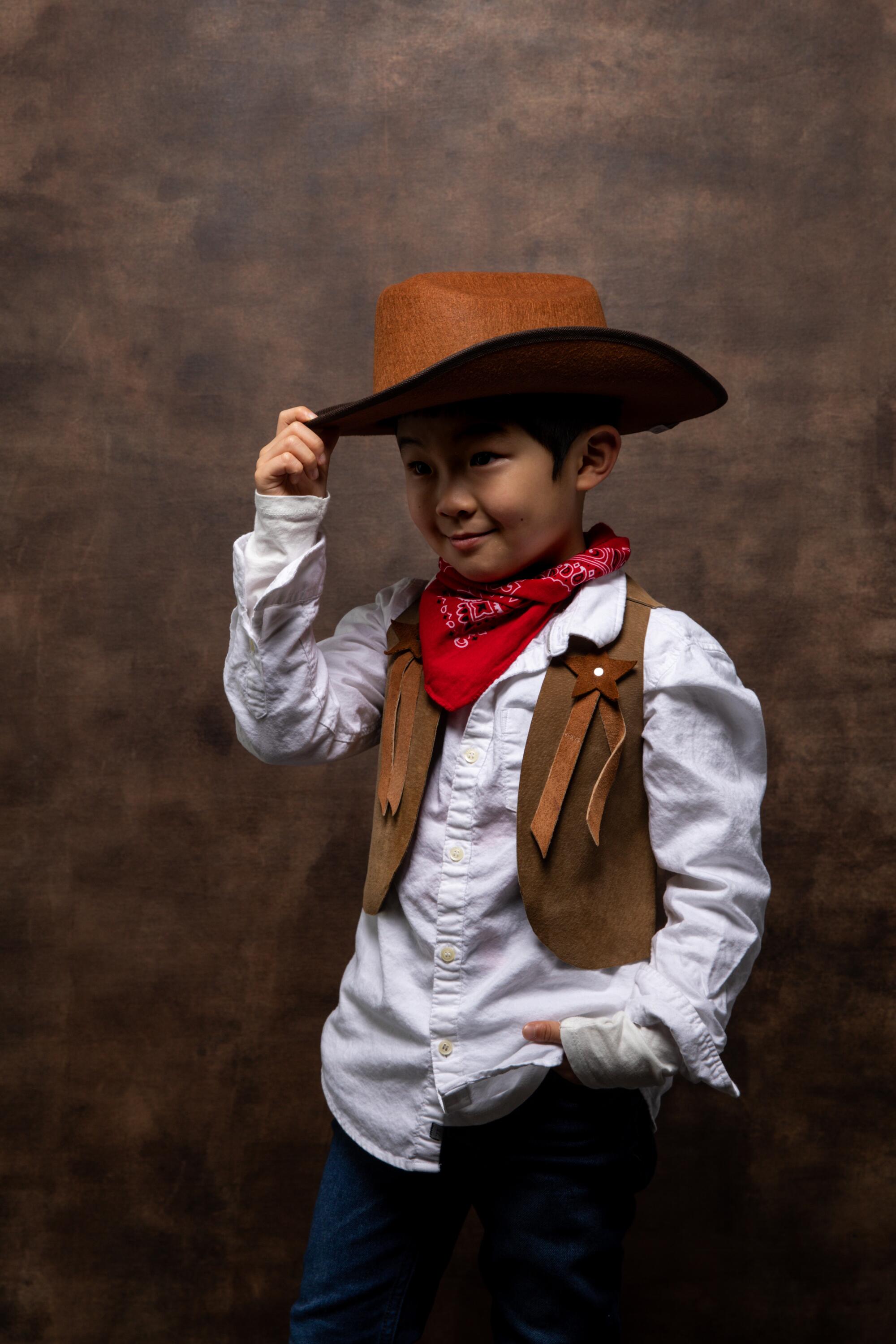 A cowboy costumed Alan Kim of “Minari” tips his hat.