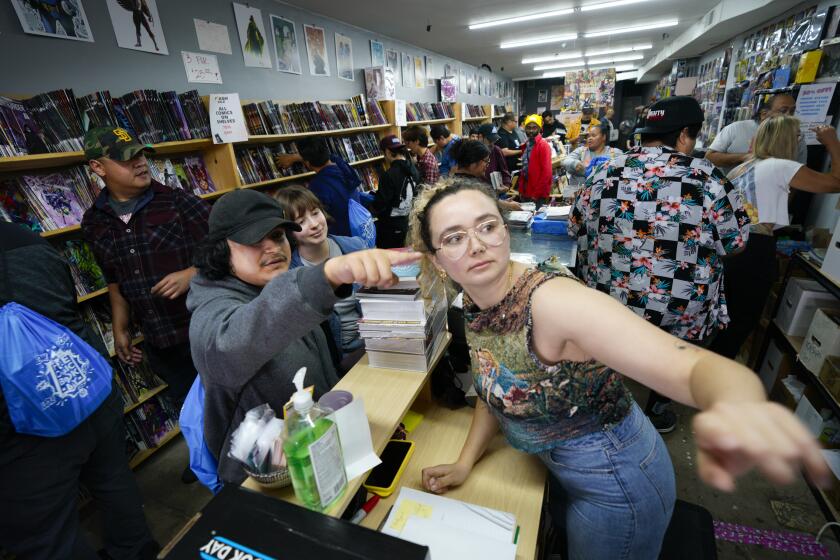 San Diego, CA - May 04: At Nuclear Comics in North Park on Saturday, May 4, 2024 in San Diego, CA, store manager, Summer Lemire (r) helped retrieve an action figure for Ysaai Osornio (l) and Daina Syshchenko (m). (Nelvin C. Cepeda / The San Diego Union-Tribune)