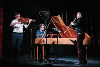 Three members of the Tesserae Baroque Ensemble play very old instruments on an otherwise darkened stage in Sierra Madre.