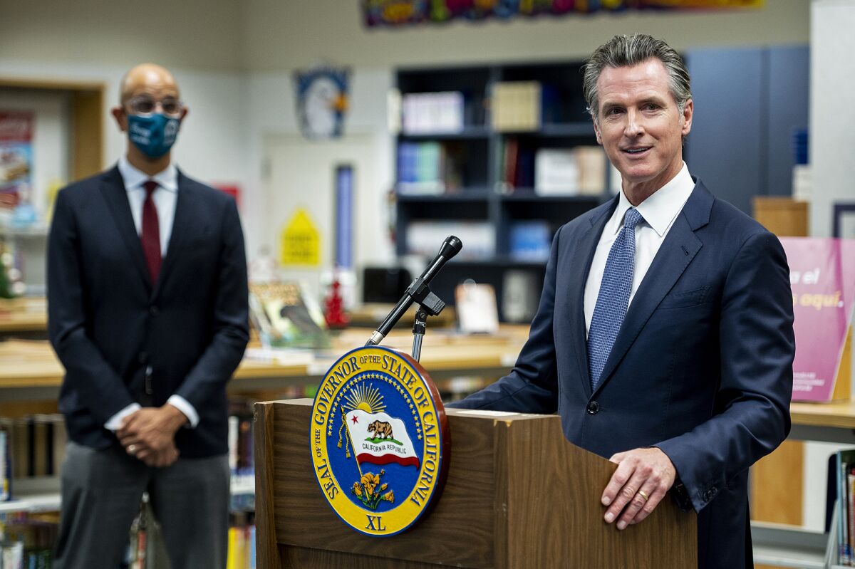 Governor Gavin Newsom announces the confirmation of California's first case of the omicron variant of COVID-19 during a visit to a vaccination clinic at Frank Sparkes Elementary School in Winton, Calif., on Wednesday, Dec. 1, 2021. (Andrew Kuhn/The Merced Sun-Star via AP)