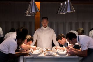 A chef supervises his underlings as they prepare dishes
