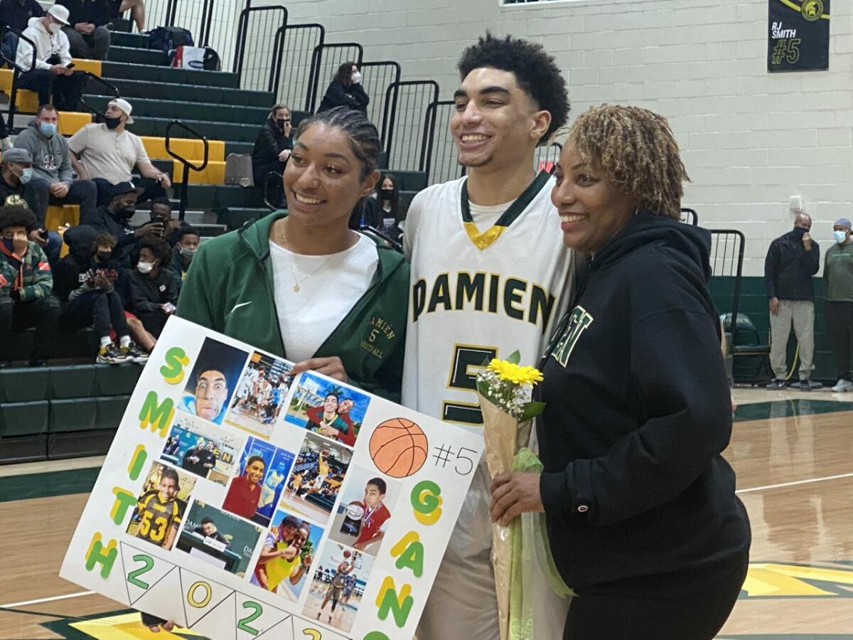 RJ Smith of Damien poses for a photo with his sister and mother.