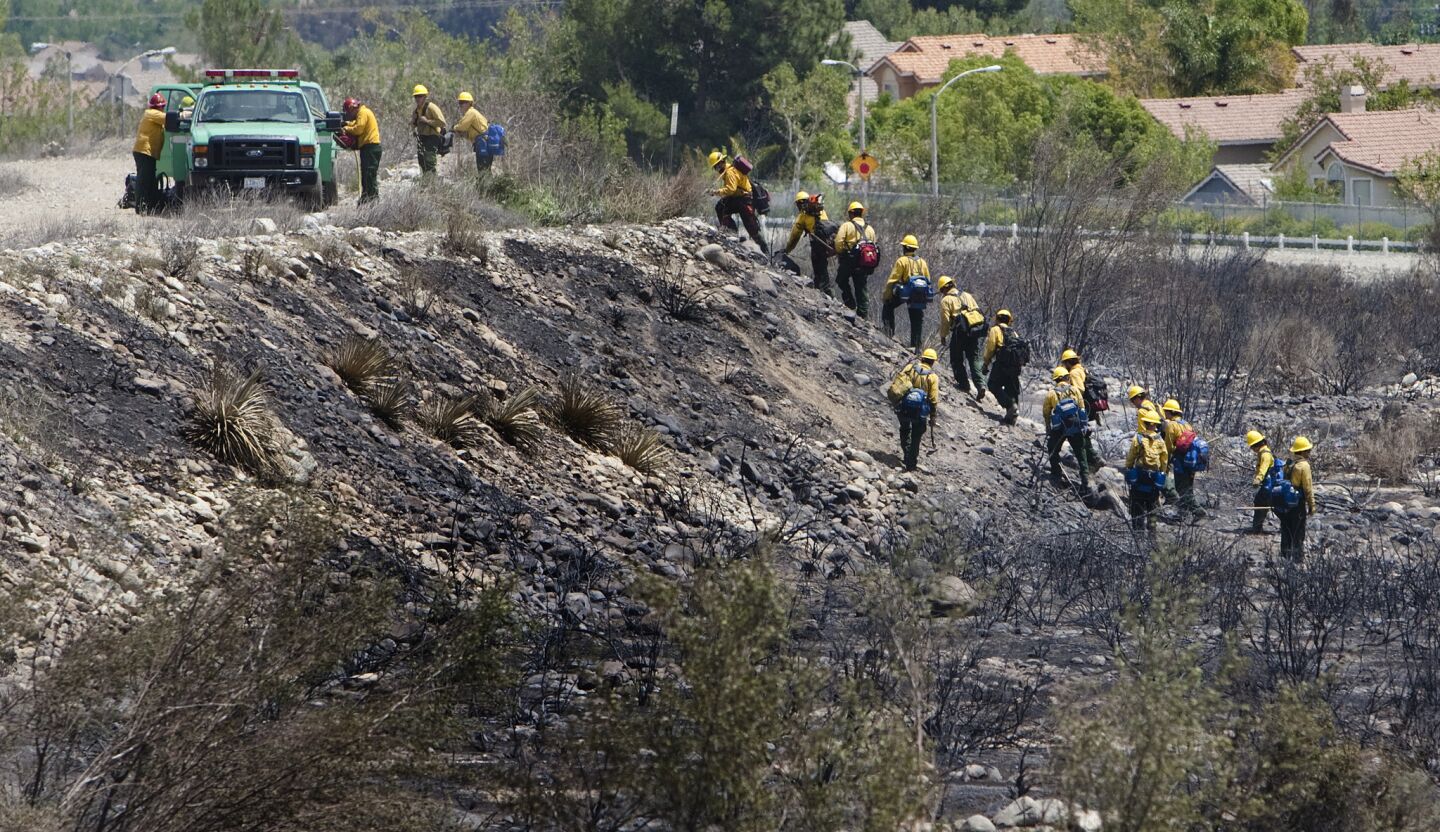 Hot shot crews traverse the burned terrain while looking for smoldering embers on the second day of the Etiwanda fire in Rancho Cucamonga.
