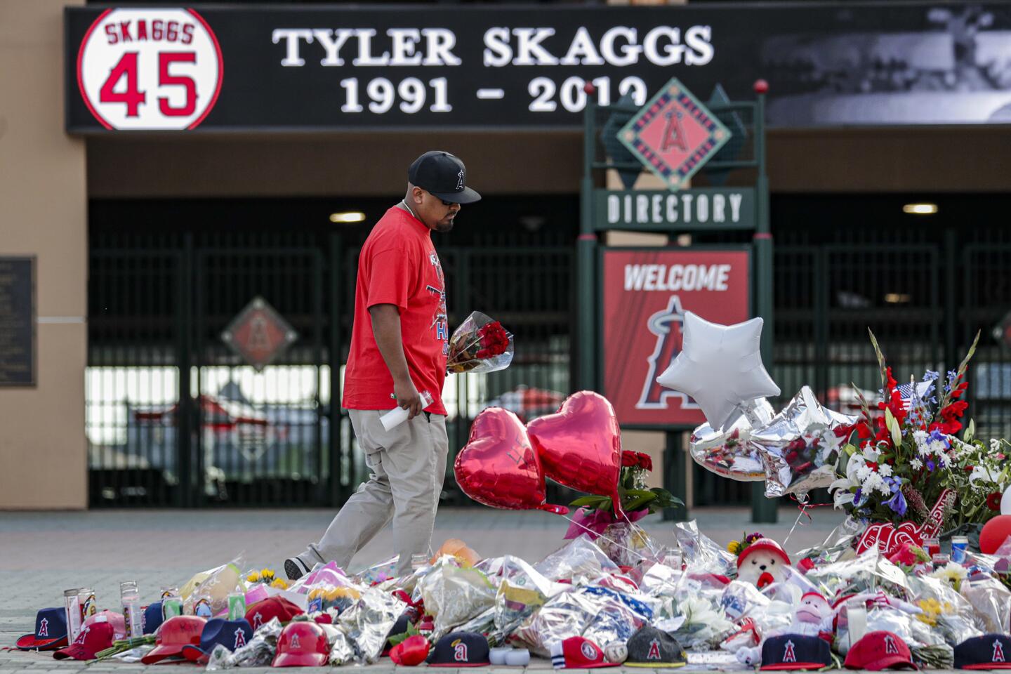 Angels fan Eric Lopez brings flowers to a growing memorial for Angels pitcher Tyler Skaggs at Angel Stadium in Anaheim.
