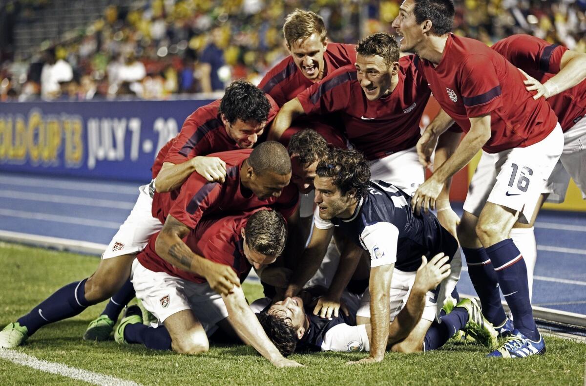No longer a forgotten man, Brad Evans is piled upon by his U.S. teammates after scoring the winning goal in stoppage time of a 2-1 victory over Jamaica on Friday.