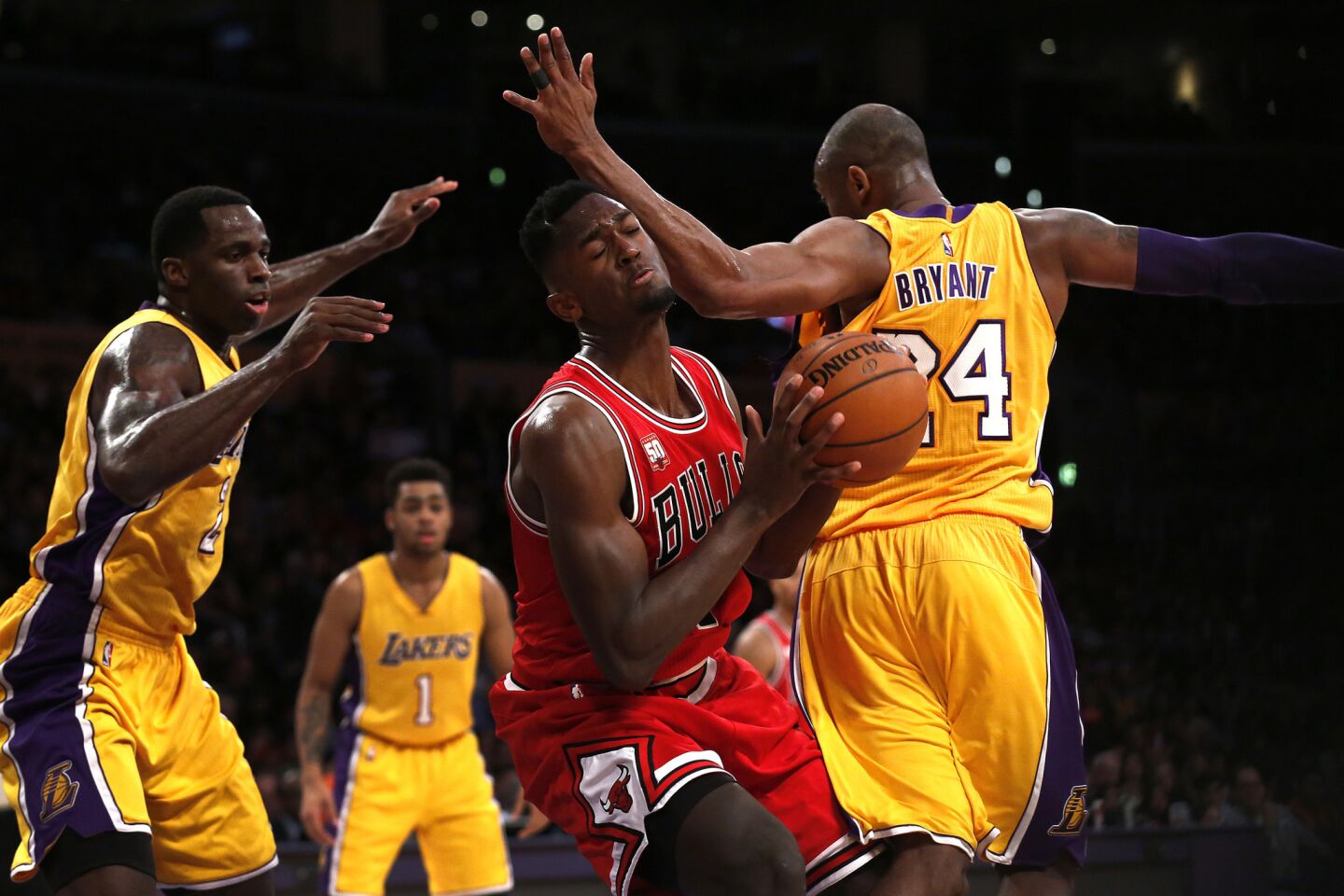 Lakers guard Kobe Bryant (24) is called for a foul as Bulls guard Bobby Portis, center, slices through the defense of Bryant and Lakers forward Brandon Bass.