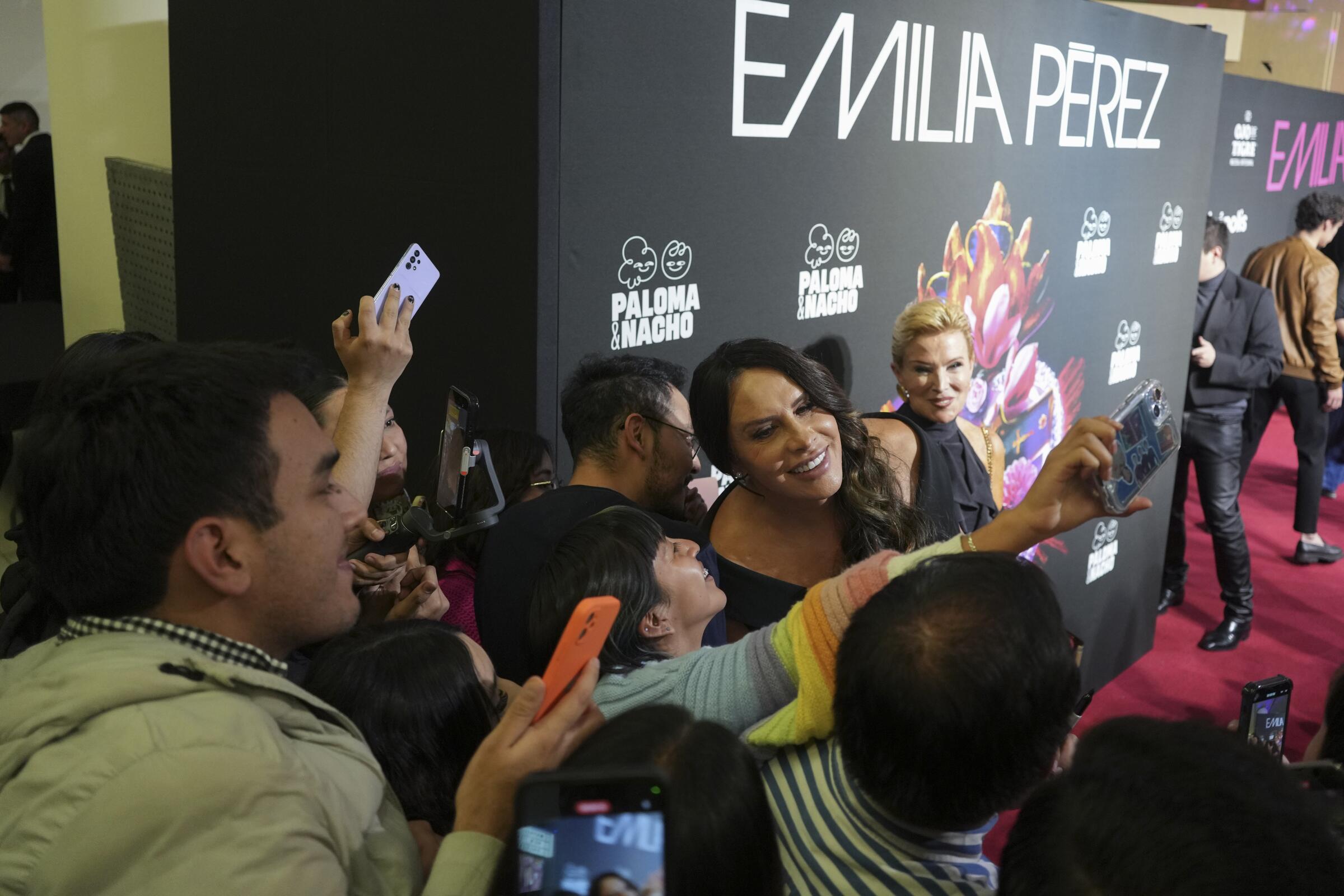 La actriz Karla Sofía Gascón interactúa con sus fans en un evento de alfombra roja