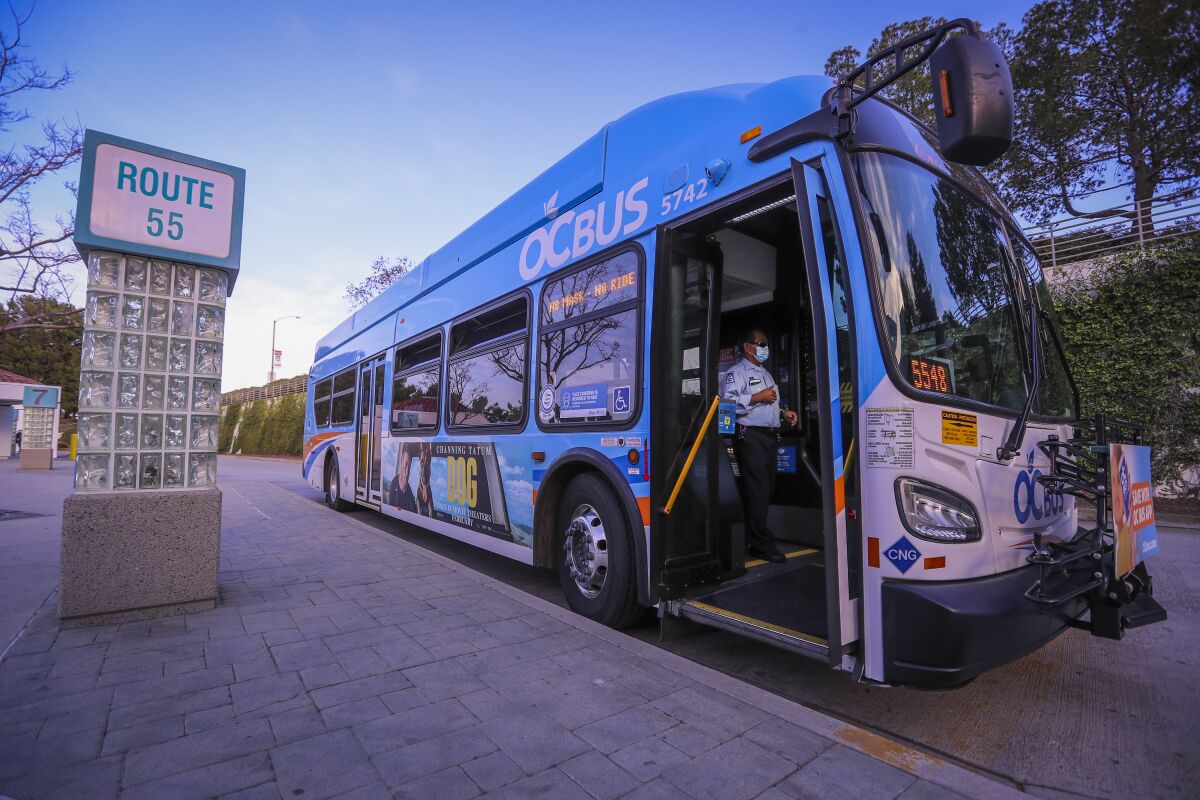 A masked Orange County Transportation Authority bus driver in Newport Beach.
