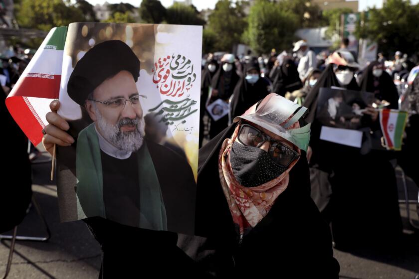 A supporter of presidential candidate Ebrahim Raisi holds a sign during a rally in Tehran, Iran, Wednesday, June 16, 2021. Iran's clerical vetting committee has allowed just seven candidates for the Friday, June 18, ballot, nixing prominent reformists and key allies of President Hassan Rouhani. The presumed front-runner has become Ebrahim Raisi, the country's hard-line judiciary chief who is closely aligned with Supreme Leader Ayatollah Ali Khamenei. (AP Photo/Ebrahim Noroozi)