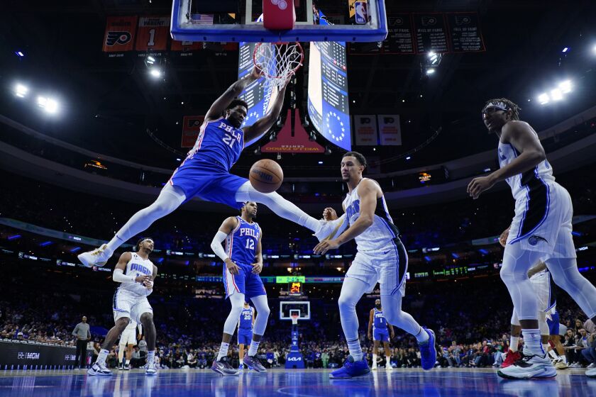 Joel Embiid (21), de los Sixers de Filadelfia, clava el balón sobre Jalen Suggs (4), del Magic de Orlando, durante la primera mitad del juego de baloncesto de la NBA, el miércoles 1 de febrero de 2023, en Filadelfia. (AP Foto/Matt Slocum)