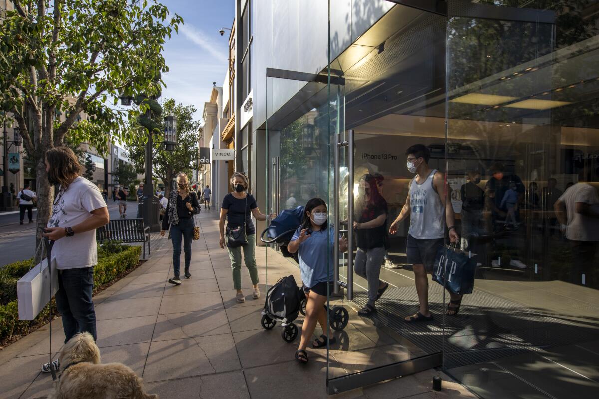 Shoppers exit the Apple Store at the Grove in Los Angeles.