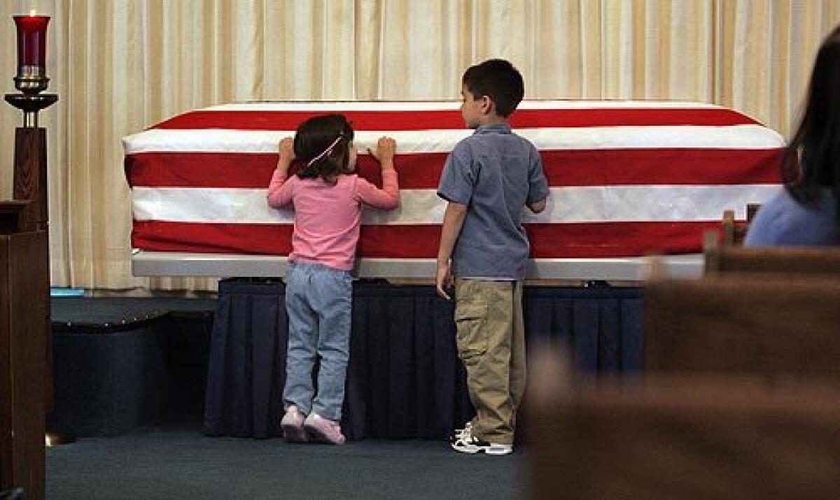Megas Roddy, 3, and Brendon Roddy, 6, nephews of Army Pfc. George Delgado, 21, of Palmdale, get a close look at his casket during a private wake at a Lancaster funeral home. Delgado and three other GIs were killed by a roadside bomb in Iraq. Now his family has to bear the unbearable.