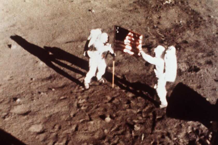 In this July 20, 1969, file photo provided by NASA, Apollo 11 astronauts Neil Armstrong and Edwin E. "Buzz" Aldrin, the first men to land on the moon, plant the U.S. flag on the lunar surface.