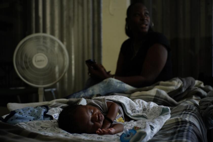 A baby sleeps inside a church that was opened up as a shelter for residents who will wait out Hurricane Dorian in Freeport on Grand Bahama, Bahamas, Sunday, Sept. 1, 2019. Hurricane Dorian intensified yet again Sunday as it closed in on the northern Bahamas, threatening to batter islands with Category 5-strength winds, pounding waves and torrential rain. (AP Photo/Ramon Espinosa)