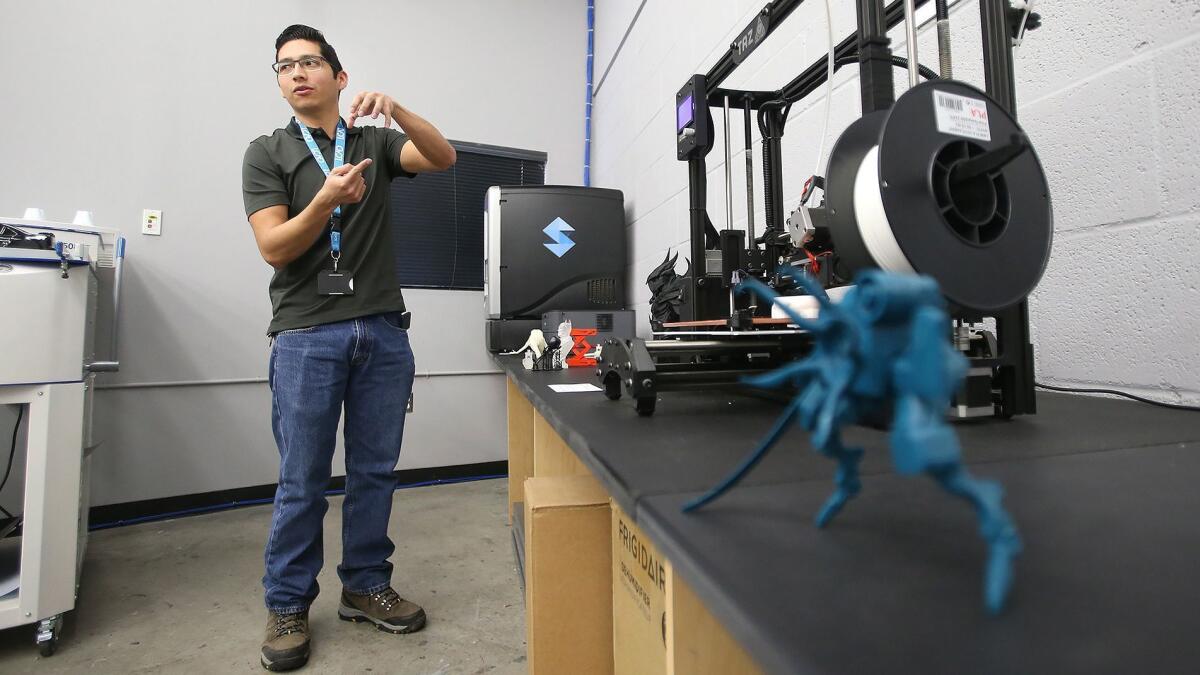 Hugo Hernandez, manager of Laguna College of Art + Design’s new Fabrication Laboratory, or “Fab Lab,” demonstrates the process in which students can take digital work designed on a computer and create a 3-D print.