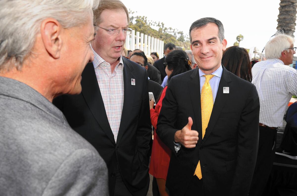 Mayor Eric Garcetti, right, talks with Olympic gold medalist Greg Louganis, left, after a news conference to announce the council's approval of a bid for the 2024 Olympic Games.