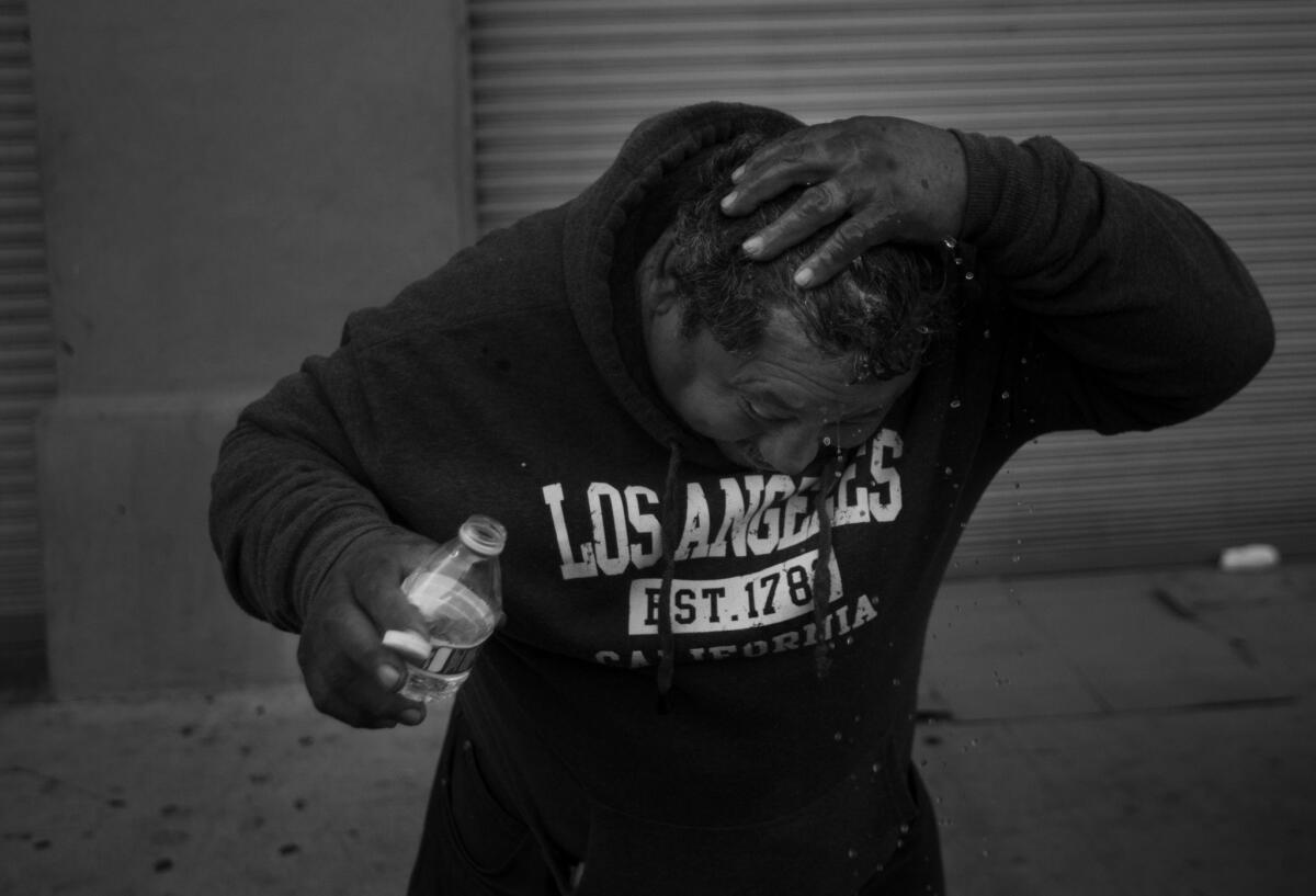 Oscar Gonzalez, 50, showers using a small bottle of water before he heads off to work in Los Angeles. Gonzalez said he has been homeless for five years.