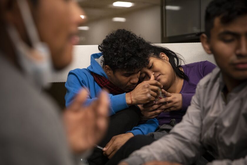 San Diego, California - December 23: Asylum seekers from Peru and Ecuador wait in the San Diego International Airport after being dropped off by Federal officials at a transit center in El Cajon with no where to go on Friday, Dec. 23, 2022 in San Diego, California. More than 75 migrants seeking asylum were left at the El Cajon Transit Center. (Ana Ramirez / The San Diego Union-Tribune)
