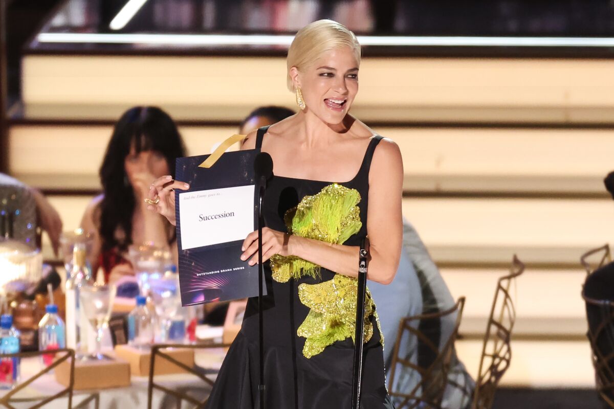 A woman in a black dress holding an envelope .