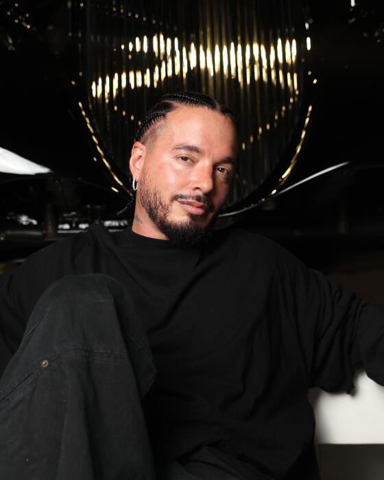 Singer J Balvin poses for a portrait in front of a 1925 Rolls-Royce Phantom at the Petersen Automotive Museum.