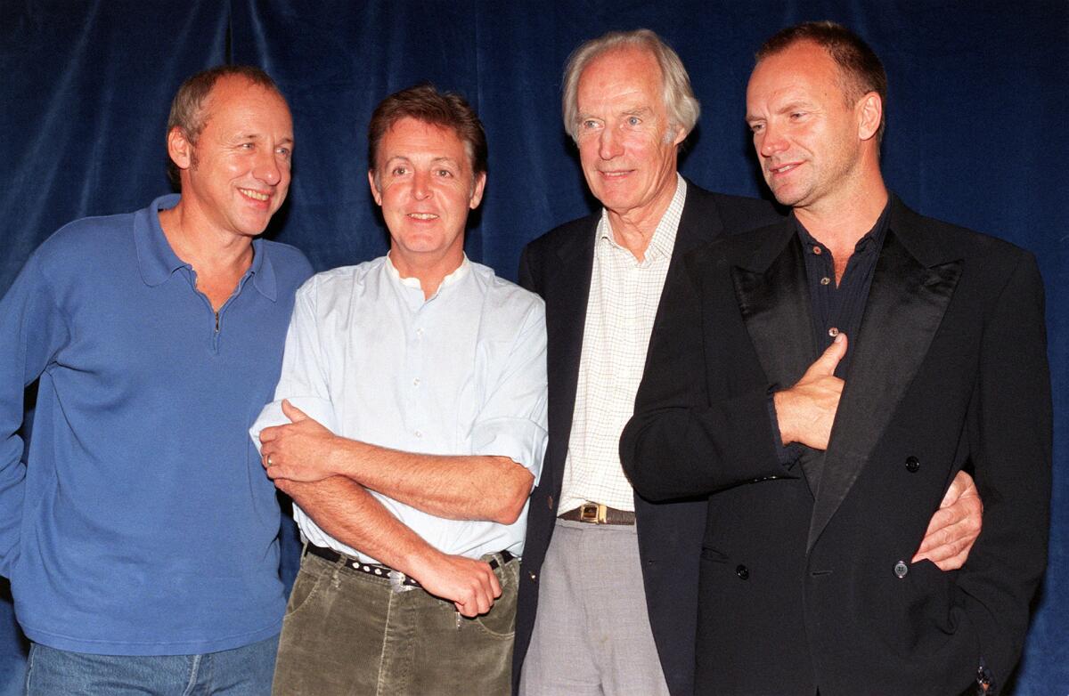 En esta foto del 15 de septiembre de 1997 file, el productor George Martin, segundo de la derecha, posa con los músicos Mark Knopfler, Paul McCartney y Sting, previo al inicio del concierto benéfico Music for Montserrat, en Londres.