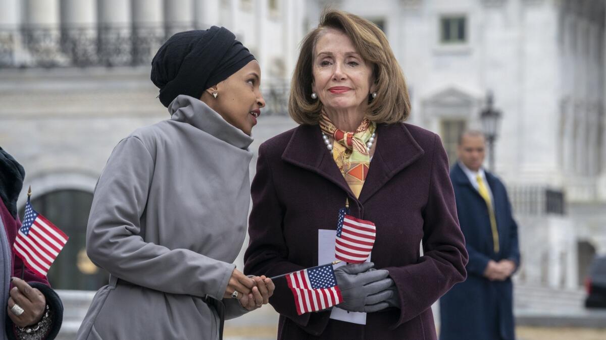 Rep. Ilhan Omar (D-Minn.), left, whispers to House Speaker Nancy Pelosi (D-San Francisco) in Washington.