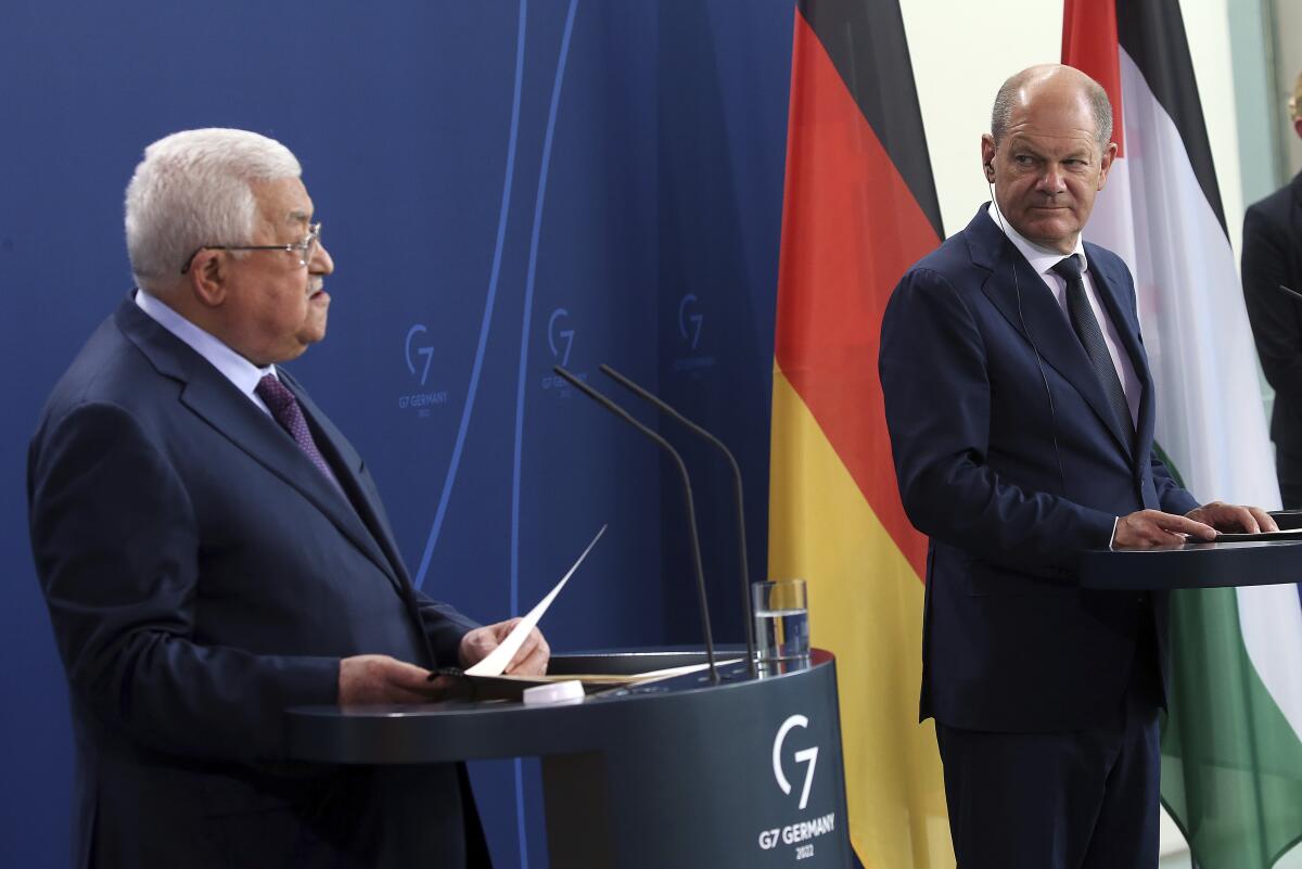 Palestinian President Mahmoud Abbas, left, speaks during a news conference after a meeting with German Chancellor Olaf Scholz, right, at the Chancellery in Berlin, Tuesday, Aug. 16, 2022. German Chancellor Olaf Scholz said on Wednesday, Aug. 17, 2022, that “For us Germans in particular, any relativization of the singularity of the Holocaust is intolerable and unacceptable. I condemn any attempt to deny the crimes of the Holocaust.” ( Wolfgang Kumm/dpa via AP)