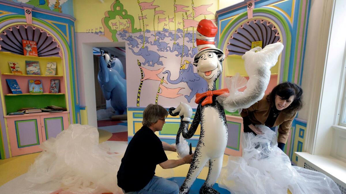 John Simpson, project director of exhibitions for the Amazing World of Dr. Seuss Museum, and his wife, Kay Simpson, president of Springfield Museums, unwrap a statue.