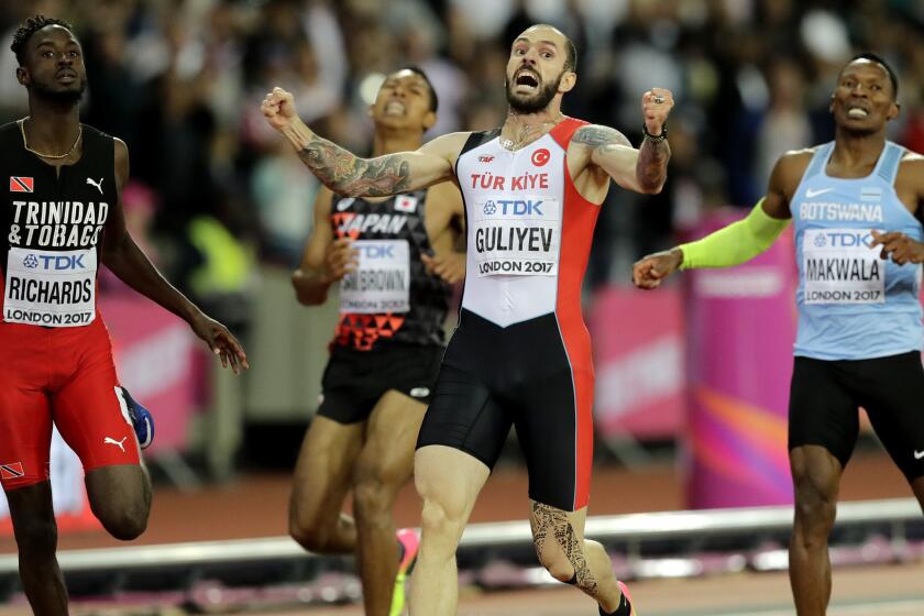 Turkey's Ramil Guliyev, second right, celebrates after winning the gold medal in the Men's 200m final Trinidad ahead of Tobago's Jereem Richards, left, who took bronze during the World Athletics Championships in London, Thursday, Aug. 10, 2017. (AP Photo/Tim Ireland)