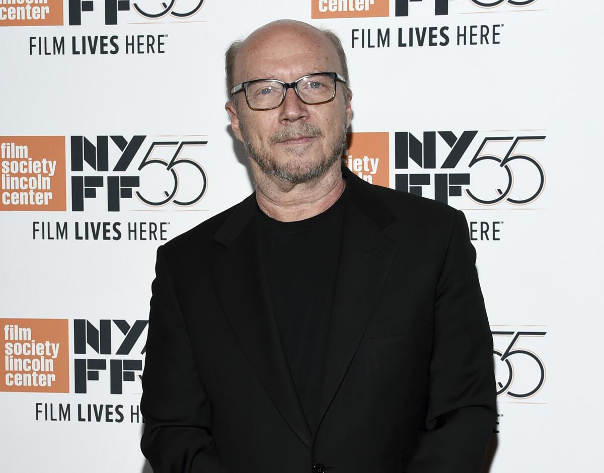 A bald man wearing glasses and a black shirt and suit